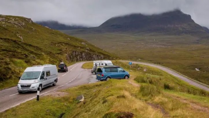 tourists signing nc500 responsible travel pledge scotland highlands